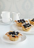 Four filo pastry baskets with vanilla pudding and blueberries