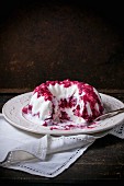 Sliced ice cream cake with berry sauce, on a vintage plate