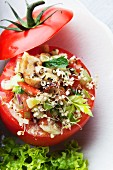 A tomato filled with quinoa sprouts and vegetables