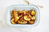Oven-roasted potatoes and chicken wings with lemons and thyme