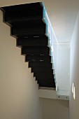 Untersicht einer schwarzen Treppe in schmalem, weißem Treppenhaus