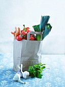 An arrangement of vegetables with a paper bag