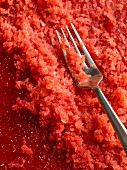 Raspberry granita with a fork (close-up)