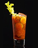 A Bloody Mary cocktail in a glass on a black surface