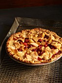 A whole berry pie on a cooling rack