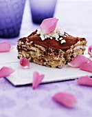 A slice of triamisu garnished with grated white chocolate and rose petals
