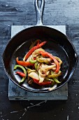 Caramelised onions and peppers in a cast-iron pan