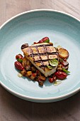 Grilled swordfish steak with aubergines and oven-roasted tomatoes