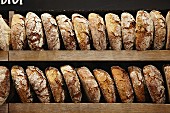 Loaves of organic bread on a wooden shelf in a bakery