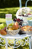 Früchte, Gläser & Muffins auf Metalltischchen im sommerlichen Garten