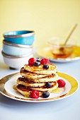 Pancakes topped with blueberries, raspberries and maple syrup (USA)