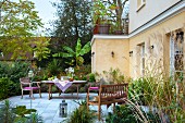 Terrasse mit Gartenmöbeln vor französischem Landhaus