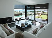 Sofas, coffee table and classic rocking chair in living room with sea view