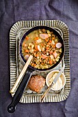 Lentil soup with sausage, a bread roll and butter