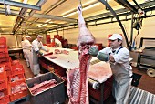 Metzger beim Zerlegen von Schweinehälften, Deutschland