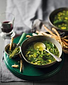 Green vegetable soup with pesto and breadsticks