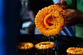 Hot jalebis being removed from oil (sweet piped pastries, India)