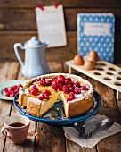 A sliced cheesecake with raspberries served with coffee