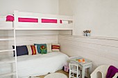 Bunk-beds with ladder, children's chair and table and wainscoting in white bedroom
