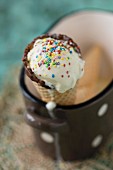 Vanilla ice cream in a cone with hundreds and thousands