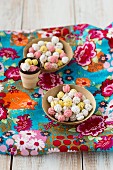 Two bowls of sugared chickpeas on a piece of floral-patterned fabric