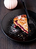 A slice of Linzertorte (nut and jam layer cake) with cherries