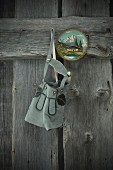 Lederhosen and painted wooden plate hanging on weathered wooden wall
