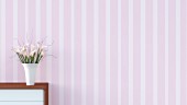 Sideboard with vase of flowers against striped pink wallpaper