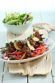 Lamb skewer with courgette on a tomato salad