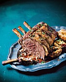 Rack of beef with herbs, Yorkshire pudding and horseradish gravy on a serving platter