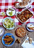 Rustikal gedeckter Tisch mit Kräuterhähnchen, Süsskartoffelgratin und Salat