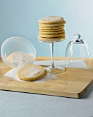A stack of sugared biscuits on a glass cake stand