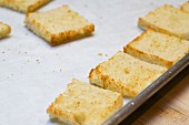 Toasted white bread with the crusts cut off on a baking tray