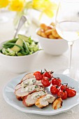 Stuffed chicken breast with roasted cherry tomatoes, vegetable salad and potatoes