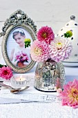 Mercury glass vase and pink dahlias on lace doily and photo of girl in antique picture frame