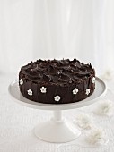 Schokoladenkuchen mit Zuckerblumen auf Kuchenständer