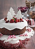 A Christmas cake with berries and fondant trees