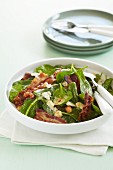 Spinach with crispy bacon, chickpeas and melted cheese