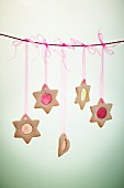Star and heart-shaped biscuits with translucent sugar windows hung on a line