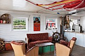 Fifties sofa set and wooden trunk used as coffee table in lounge area with white wood-clad walls