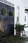 Advent arrangement of fir branches on veranda of Scandinavian house