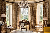 Classic desk and Baroque chairs in window bay with lattice windows and opulent curtains