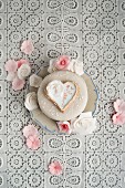 A cake decorated with fondant icing sugar, heart-shaped biscuit and sugar roses