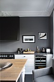 Kitchen with rustic dining table and kitchen counter against dark grey wall