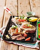 Grilled tuna fish steaks with pineapple and citrus fruits