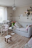 Rocking chair and sofa with striped pastel cover in Scandinavian country-house style