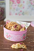Biscuits with dried rose petals in biscuit tin with pattern of roses