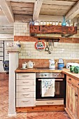 Rustic interior with white drawers in base units of open-plan kitchen