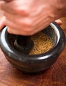 A spice mixture being ground in a mortar