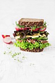 Grosses Sandwich mit Salat, Schinken, Käse, Gurken, Radieschen, Kresse und Vollkornbrot